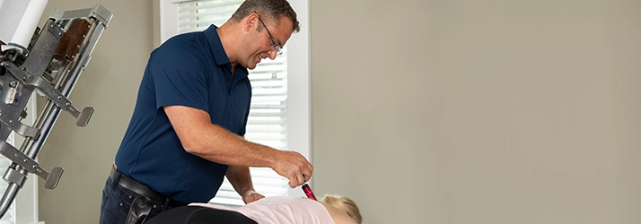 Chiropractor Lawrenceville GA Chris Canning Using Activator Device On Patient